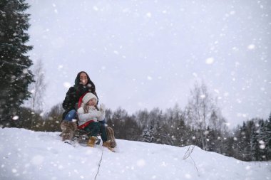 Bir kış masal, genç bir anne ve kızı bir kızak sürmek