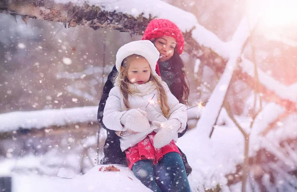 A winter fairy tale, a young mother and her daughter ride a sled