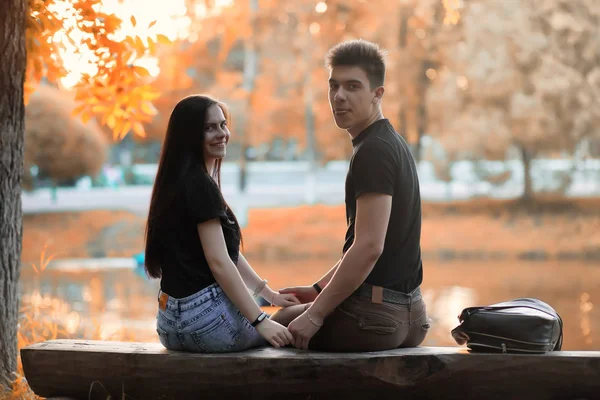 Pareja joven en un paseo en el parque de otoño —  Fotos de Stock