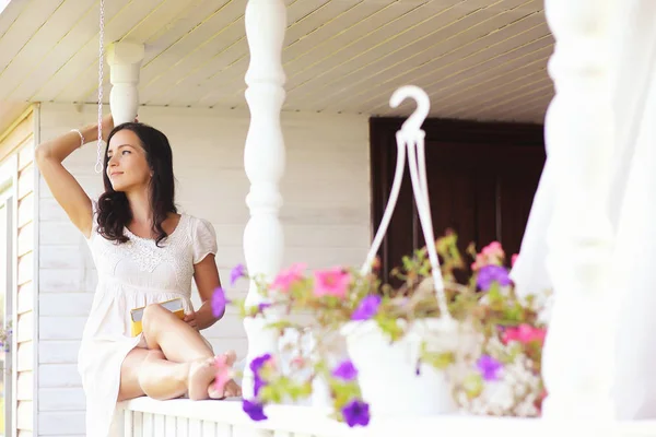 En ung tjej med en dotter är att plocka upp en bukett. En ung mor med sin dotter gör en blomma. Sommarhus i byn av trädgården. Vila i byn. — Stockfoto