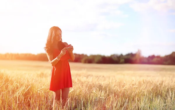 Ragazza in un campo di grano. Paesaggio estivo e una ragazza su un na — Foto Stock