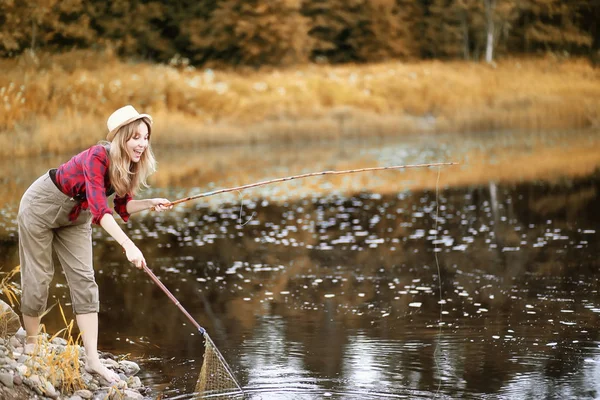 Chica en otoño con una caña de pescar — Foto de Stock