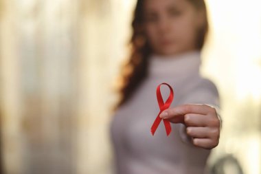 Kırmızı kurdele kızın. Kız kırmızı kurdele tutuyor. O