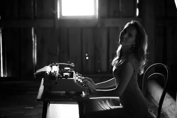 Een meisje wordt afgedrukt op een oude typemachine — Stockfoto