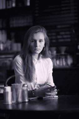 Bir kız bir kafede kahve içiyor. Bir kadın kahvaltı yapıyor