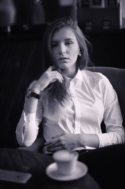 Bir kız bir kafede kahve içiyor. Bir kadın kahvaltı yapıyor