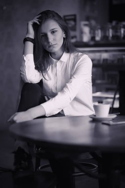 Bir kız bir kafede kahve içiyor. Bir kadın kahvaltı yapıyor