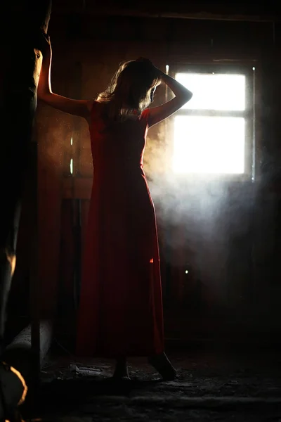 Silhouette of a beautiful girl in a red dress — Stock Photo, Image