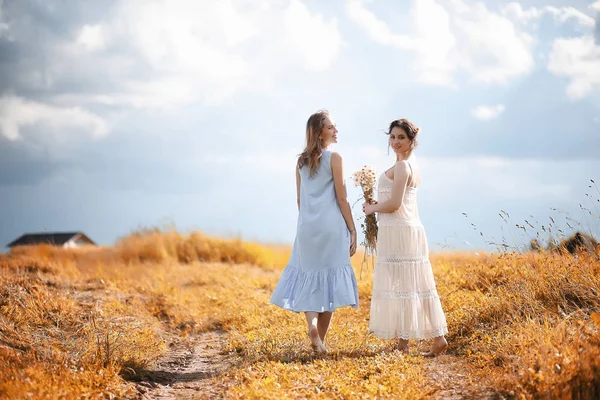 Duas meninas em vestidos no campo de outono — Fotografia de Stock