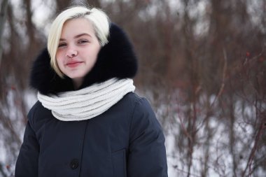 Genç ve güzel bir kız kış parkında yürüyüşe çıkmış.