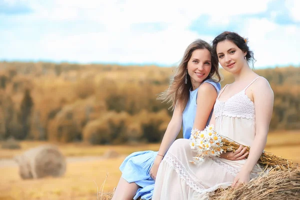 Dos chicas en vestidos en el campo de otoño — Foto de Stock