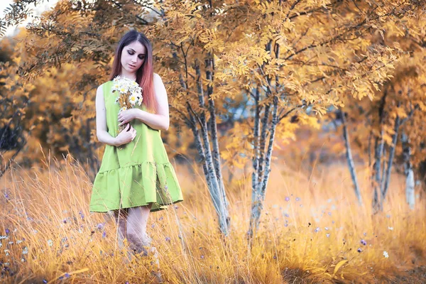 Menina bonita com um buquê no outono — Fotografia de Stock