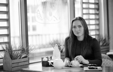 Bir kafede otururken ve tatlı ile çay içme güzel kız