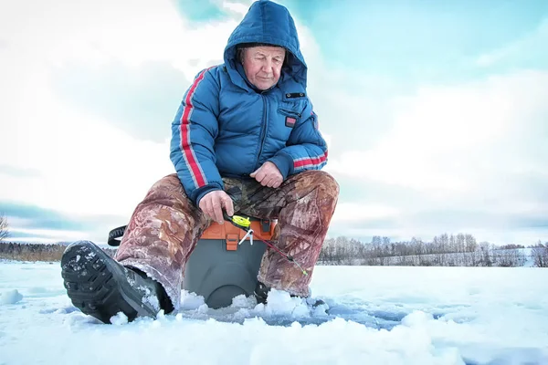 Зимний сезон старик рыбачит на озере — стоковое фото