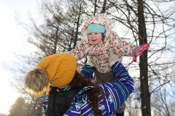 Föräldrar som håller barn på händerna i vinterparken — Stockfoto