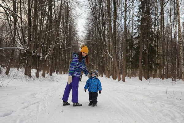 Ung med familj ha kul i en vinterpark — Stockfoto