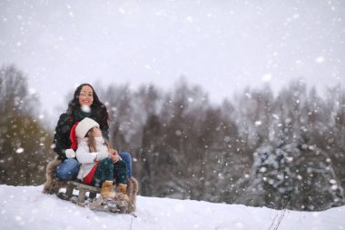 Bir kış masal, genç bir anne ve kızı bir kızak sürmek