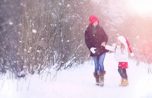 En vintersaga, en ung mamma och hennes dotter rida en släde — Stockfoto