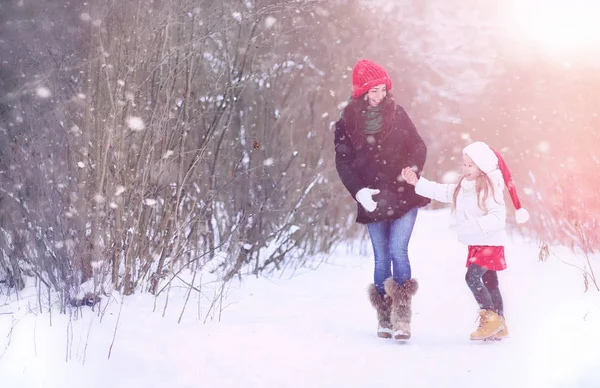 A winter fairy tale, a young mother and her daughter ride a sled