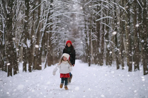 Зимняя сказка, молодая мать с дочерью катаются на санках — стоковое фото