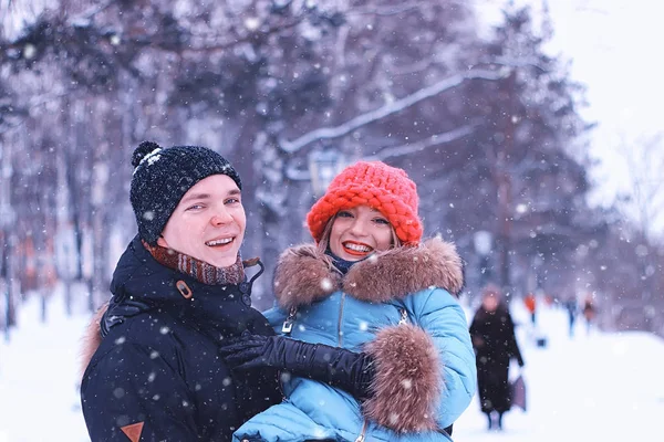 Hombre lleva a una chica joven pareja en invierno — Foto de Stock