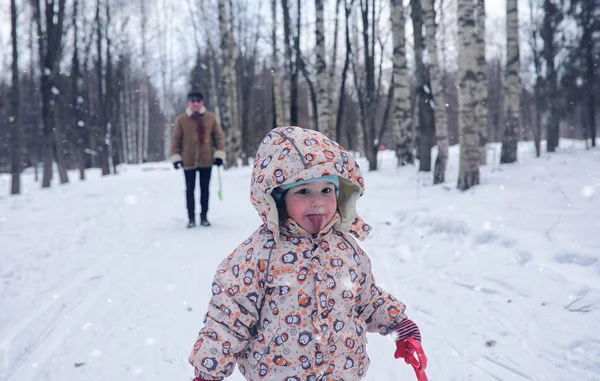 Ungen leker i en vinterpark och ha kul med familjen — Stockfoto