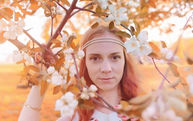 Bir parkta yürümek bir kız. Bahar Kızıl saçlı kız 