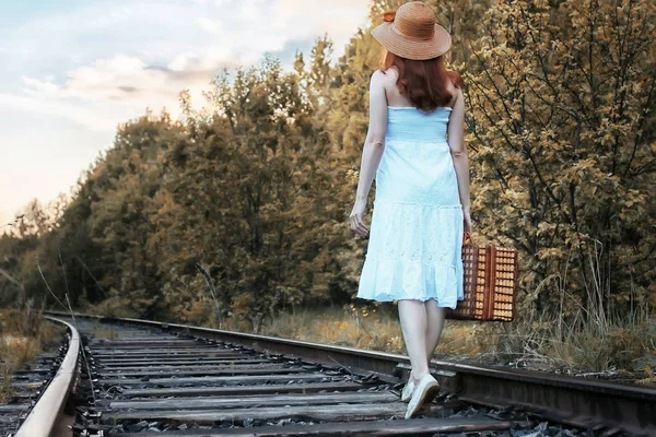 Осінній парк дівчина в білому сараї і плетена валіза ходьби — стокове фото