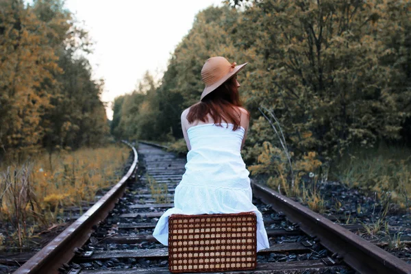 Осінній парк дівчина в білому сараї і плетена валіза ходьби — стокове фото