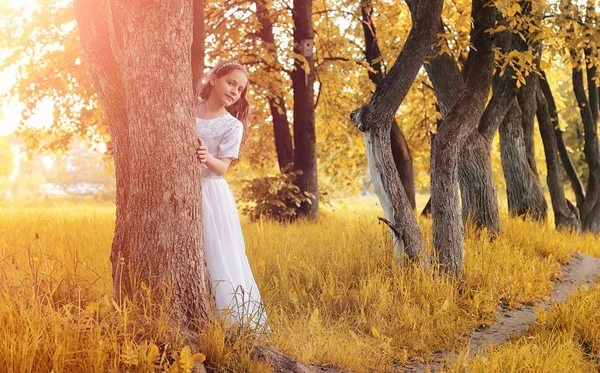 Teenager pustet Samen aus einer Löwenzahnblüte in einem Park — Stockfoto