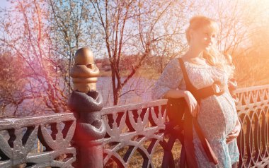 Hamile kız parkta bir yürüyüş. CI karnından kızla