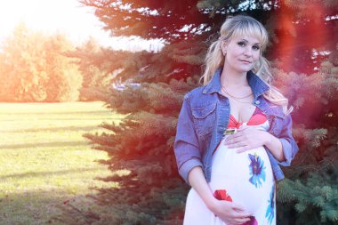 Hamile kız parkta bir yürüyüş. CI karnından kızla