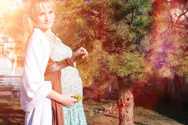 Hamile kız parkta bir yürüyüş. CI karnından kızla