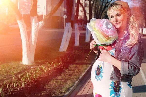 Hamile kız parkta bir yürüyüş. CI karnından kızla