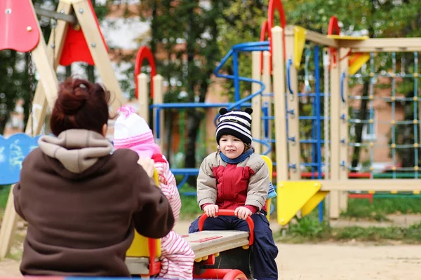 Crianças brincam no parque infantil — Fotografia de Stock