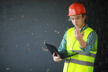 Kask ve inşaat koruyucu yelek Asyalı adam