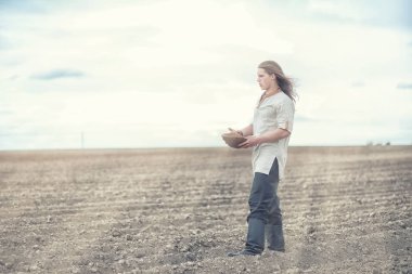 Genç bir köylü tahıl alanıyla sows