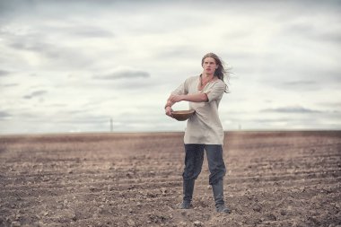 Genç bir köylü tahıl alanıyla sows