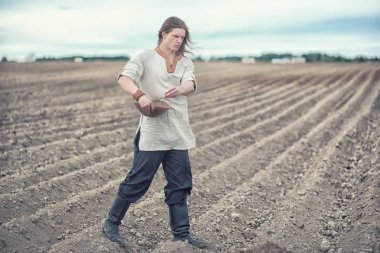 Genç bir köylü tahıl alanıyla sows