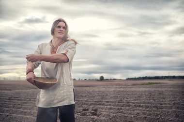 Genç bir köylü tahıl alanıyla sows