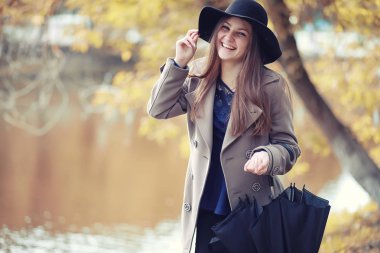 Sonbahar parkında montlu genç kız.