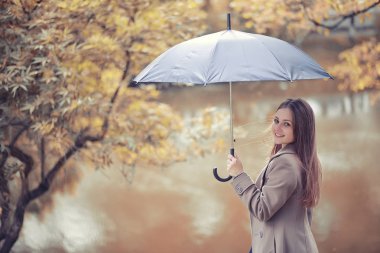 Sonbahar parkında montlu genç kız.