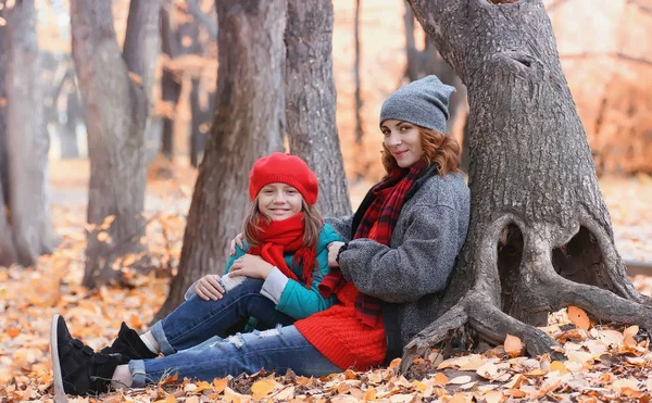 Girl in autumn city park in leaf fall. Young beautiful mother wi — Stock Photo, Image