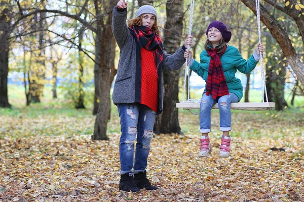 Joven hermosa madre con su hija en la naturaleza. Una chica en una — Foto de Stock