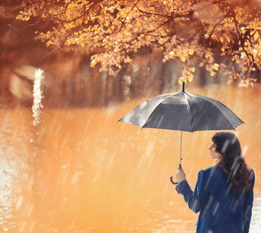 Hamile bir kadın parkta yürüyor.