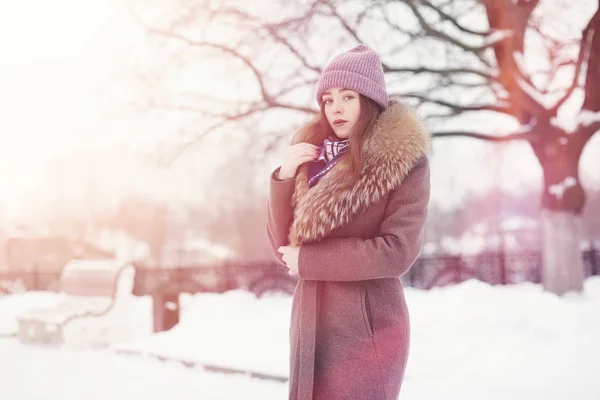 En ung pige i en vinterpark på en gåtur. Juleferie i t - Stock-foto