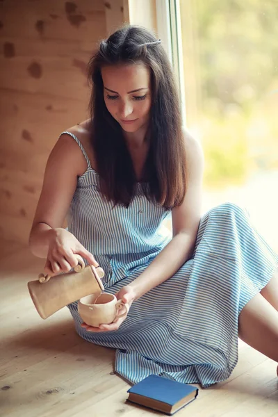 En flicka på fönstret i huset — Stockfoto