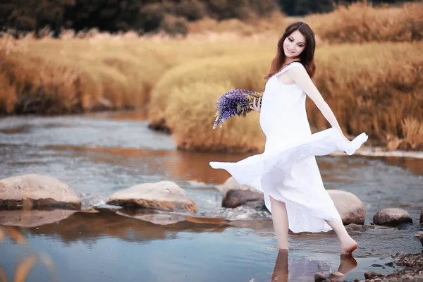 Mujer embarazada en la naturaleza para un paseo en el otoño — Foto de Stock