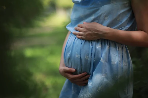 Беременная девушка в платье на природе — стоковое фото