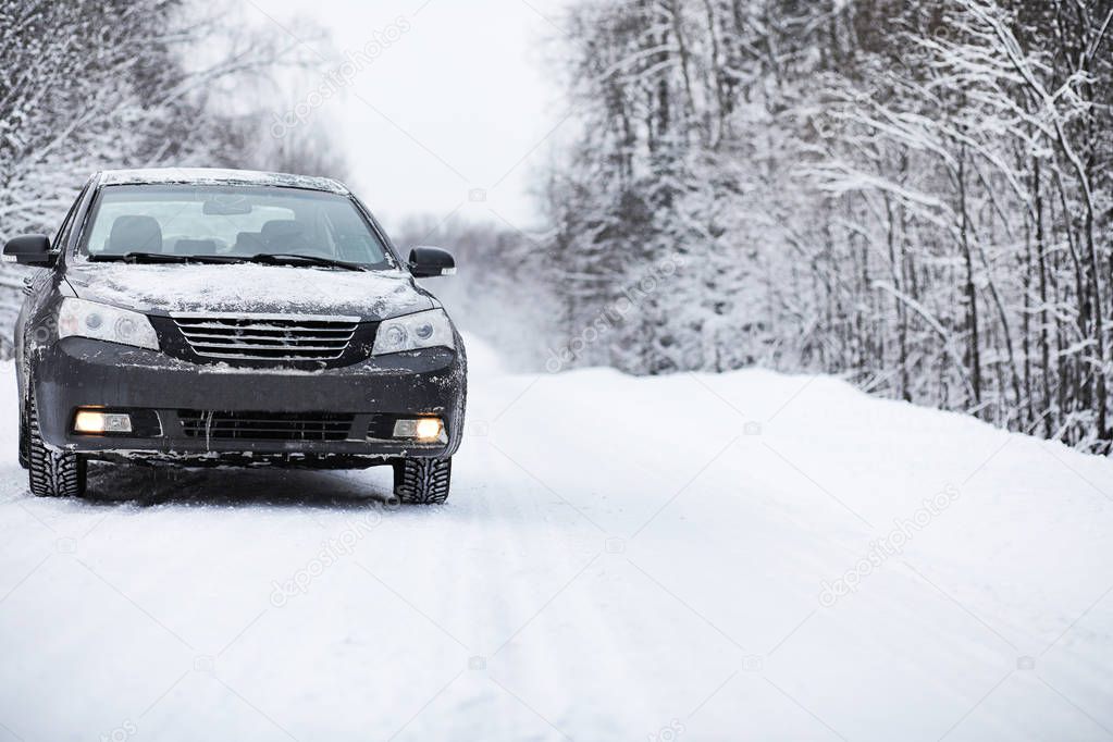 The car stands on a snow-covered road